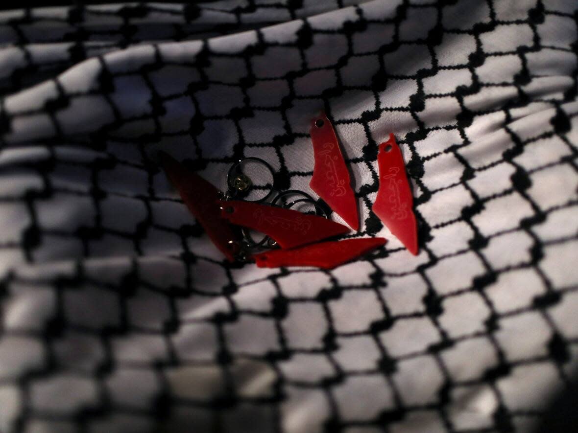 A keffiyeh is pictured with keychains resting on it at a protest in support of Palestinians in Gaza, amid the ongoing conflict between Israel and Hamas, in Amman, Jordan, on March 12, 2024.  (Alaa Al-Sukhni/Reuters - image credit)