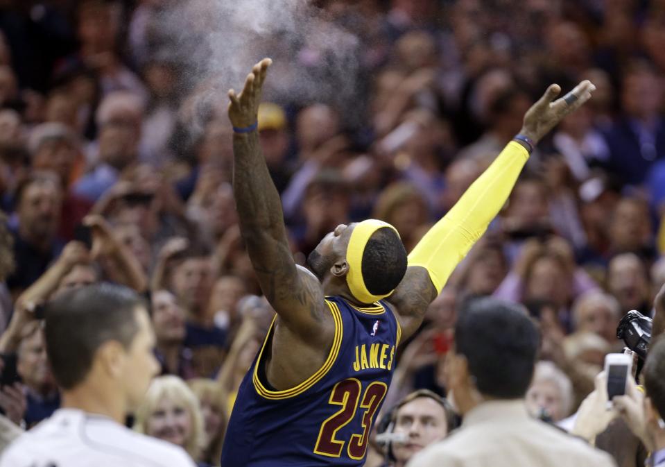 FILE - In this Oct. 30, 2014, file photo, Cleveland Cavaliers' LeBron James tosses chalk in the air before the start of an NBA basketball game against the New York Knicks in Cleveland. LeBron returns to Miami, when he and the Cleveland Cavaliers play the Heat on Christmas Day.