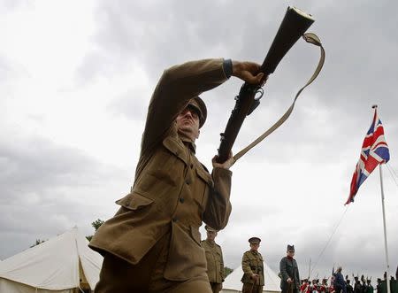 Custom silicone technician Corin Watts, portraying a Lance Corporal in the Kings Royal Rifle Corps, part of the Rifles Living History Society, participates in a rifle drill whilst recreating life as a First World War soldier at the Colchester Military Tournament in Colchester, eastern England July 6, 2014. REUTERS/Luke MacGregor