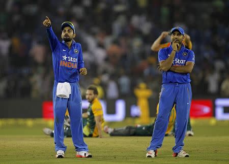 India's Virat Kohil (L) and Rohit Sharma reacts after the match was disrupted due to water bottles thrown by spectators during the second Twenty20 cricket match against South Africa in Cuttack, India, October 5, 2015. REUTERS/Danish Siddiqui