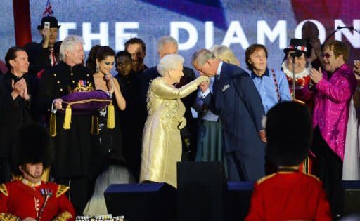 Prince Charles kisses the hand of Britain's Queen Elizabeth II on stage as British singers Paul McCartney (3rd R) and Elton John (R) and other performers look on after the Jubilee concert at Buckingham Palace