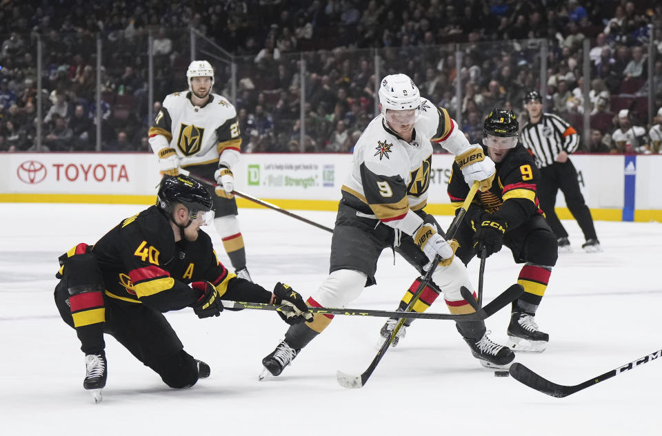 Vancouver Canucks' Elias Pettersson (40) and J.T. Miller, right, check Vegas Golden Knights' Jack Eichel, center, during the first period of an NHL hockey game Tuesday, March 21, 2023, in Vancouver, British Columbia. (Darryl Dyck/The Canadian Press via AP)