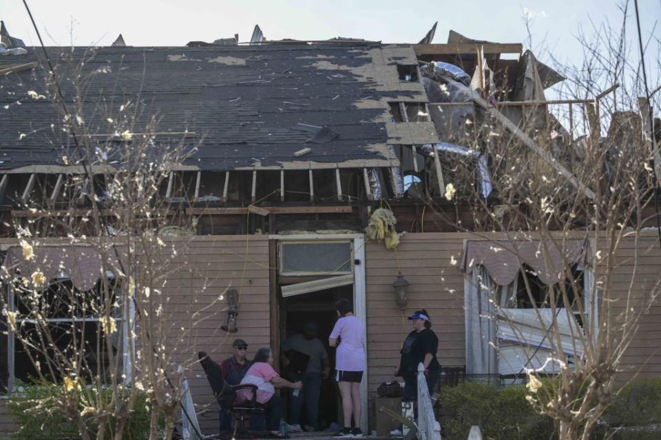 Residents survey damage to a home after a tornado ripped through Mississippi.