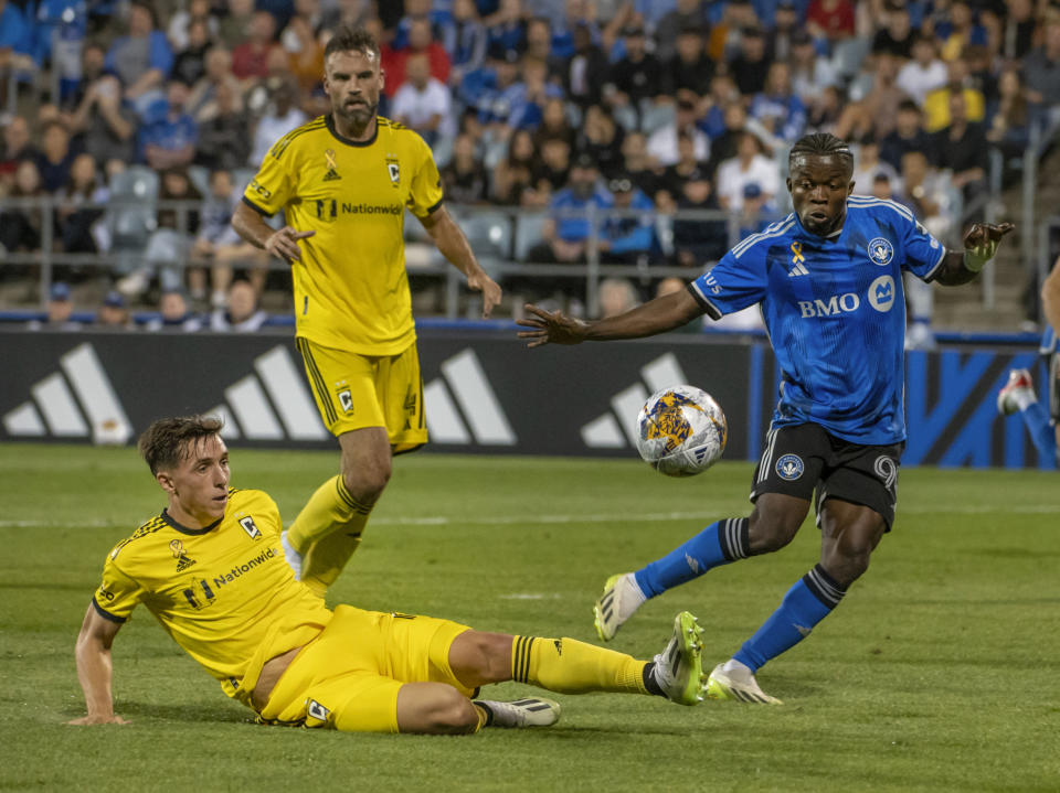 Columbus Crew's Malte Amundsen, left, slides in to block the pass intended for CF Montreal's Kwadwo Opoku during the second half of an MLS soccer match Saturday, Sept. 2, 2023, in Montreal. (Peter McCabe/The Canadian Press via AP)