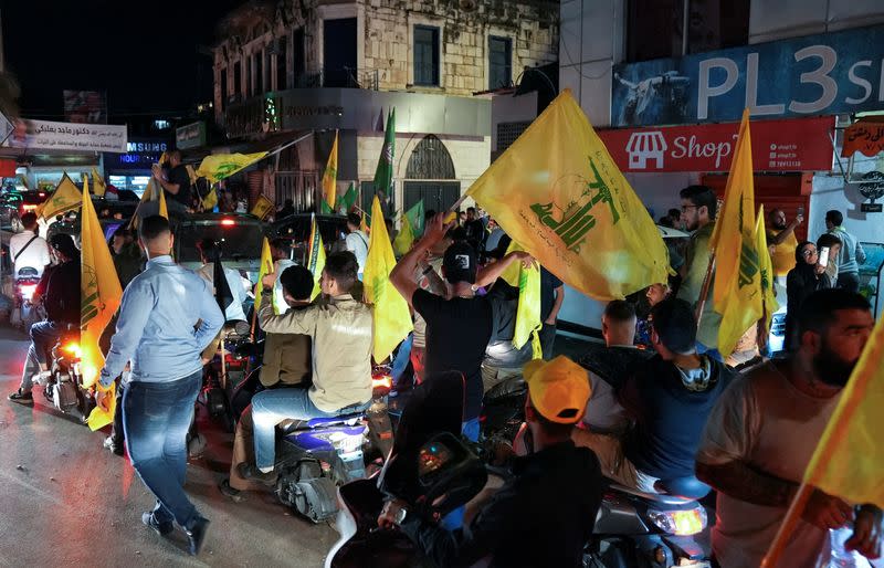 Supporters of Lebanon's Hezbollah leader and Amal Movement carry flags while riding in a convoy, in Nabatiyeh