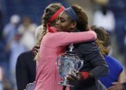 Serena Williams of the U.S. holds her winner's trophy as she embraces Victoria Azarenka of Belarus after Williams won their women's singles final match at the U.S. Open tennis championships in New York September 8, 2013. REUTERS/Adam Hunger (UNITED STATES - Tags: SPORT TENNIS)
