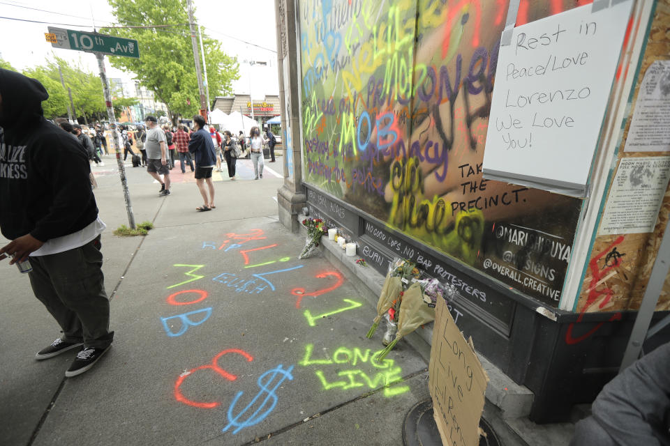A sign that reads "Rest in Peace/Love Lorenzo," is displayed at a growing memorial, Saturday, June 20, 2020, at the intersection of 10th Ave. and Pine St. near the Capitol Hill Occupied Protest zone in Seattle. A pre-dawn shooting near the area left one person dead and critically injured another person, authorities said Saturday. The area has been occupied by protesters after Seattle Police pulled back from several blocks of the city's Capitol Hill neighborhood near the Police Department's East Precinct building. (AP Photo/Ted S. Warren)