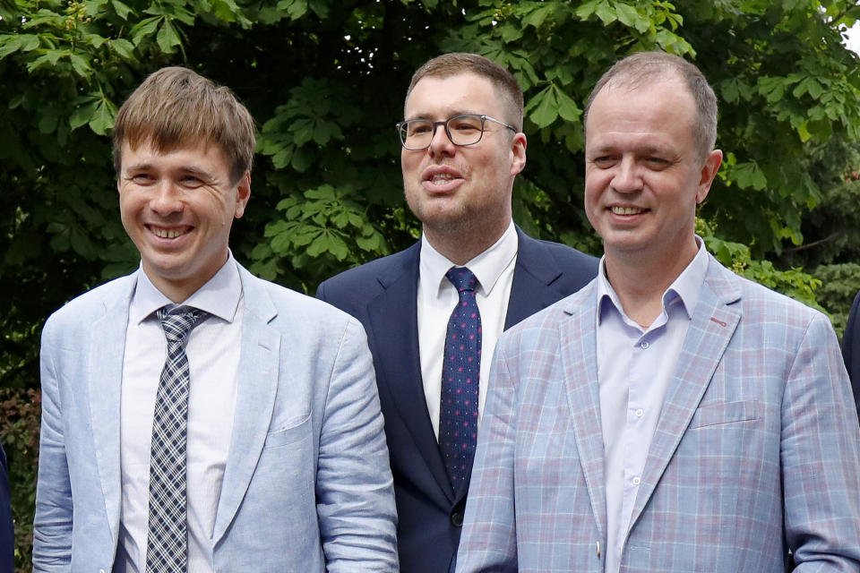 Russian lawyers Ivan Pavlov, right, Vladimir Voronin, center, and Yevgeny Smirnov smile during a break in a court session in front of Moscow Court in Moscow, Russia, Wednesday, June 9, 2021. A Moscow court has outlawed the organizations founded by Russian opposition leader Alexei Navalny by labeling them extremist, the latest move in a campaign to silence dissent and bar Kremlin critics from running for parliament in September. The Moscow City Court's ruling, effective immediately, prevents people associated with Navalny's Foundation for Fighting Corruption and his sprawling regional network from seeking public office. (AP Photo/Alexander Zemlianichenko)