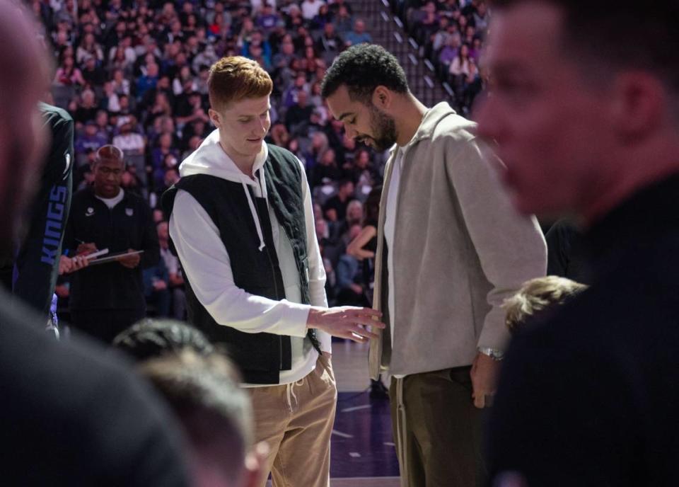 Injured Sacramento Kings guard Kevin Huerter (9) and teammate Trey Lyles (41) talk during a timeout at an NBA game against the Dallas Mavericks on March 29, 2024, at Golden 1 Center.