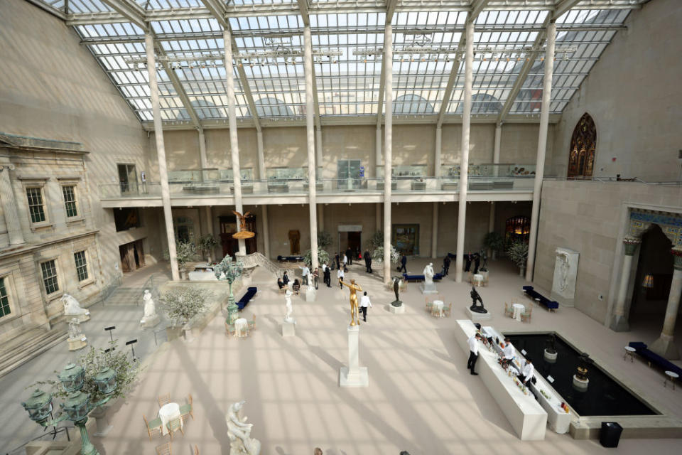 Interior of a museum with sculptures and visitors walking around