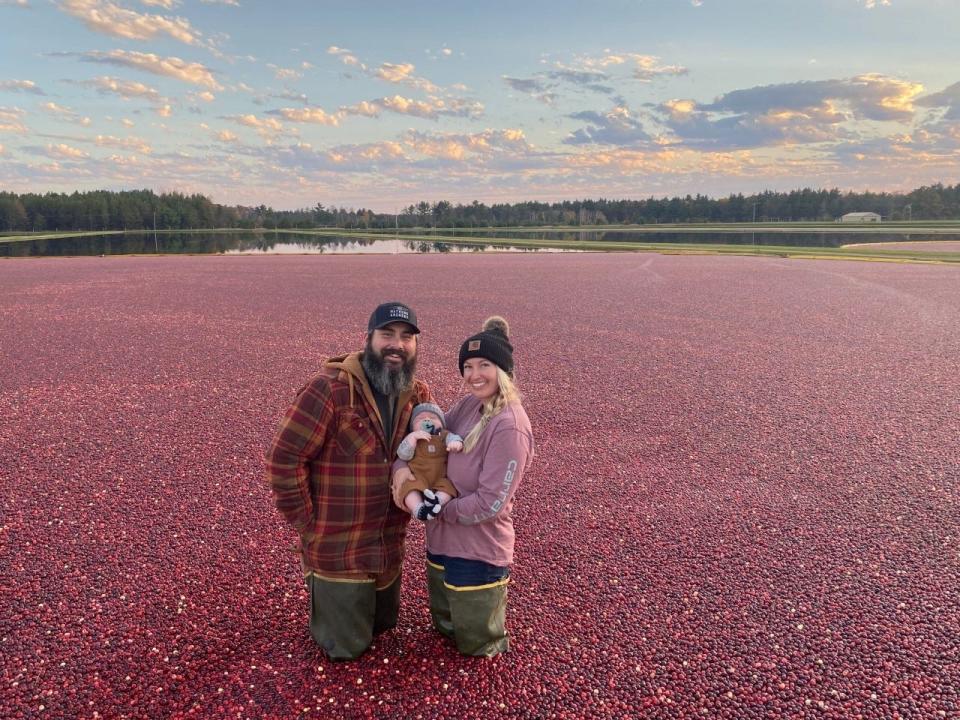 Amber Bristow is shown with her husband, Dan, and newborn son, Porter, at their family cranberry farm.