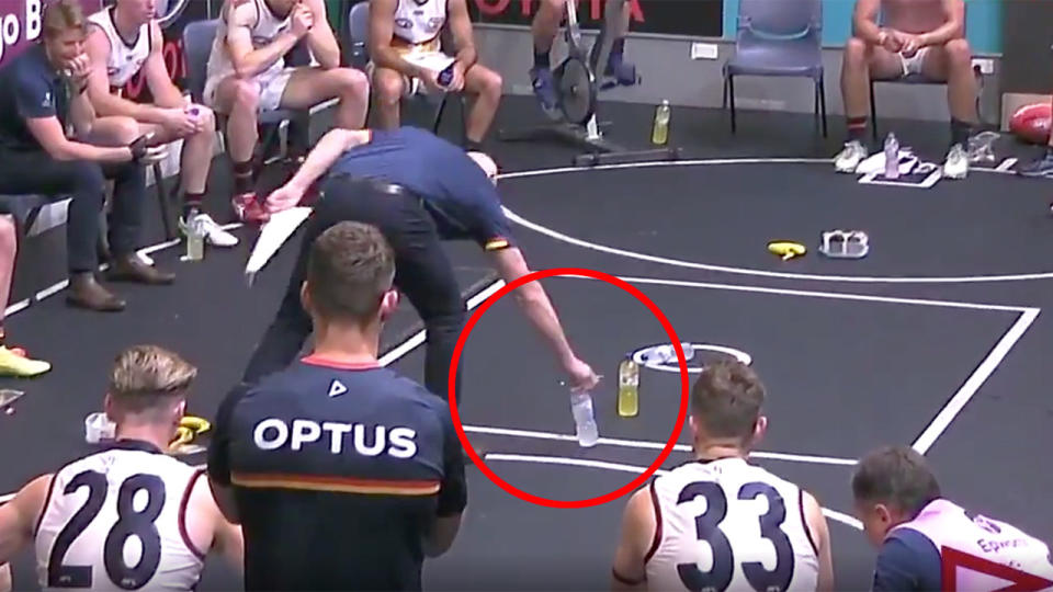 Pictured here, Adelaide coach Matthew Nicks uses water bottles to explain tactics to his players.