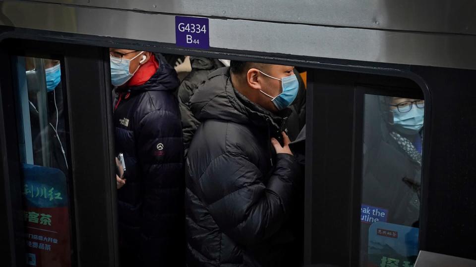 Pendler in Peking drängen sich während der Hauptverkehrszeit in eine U-Bahn.