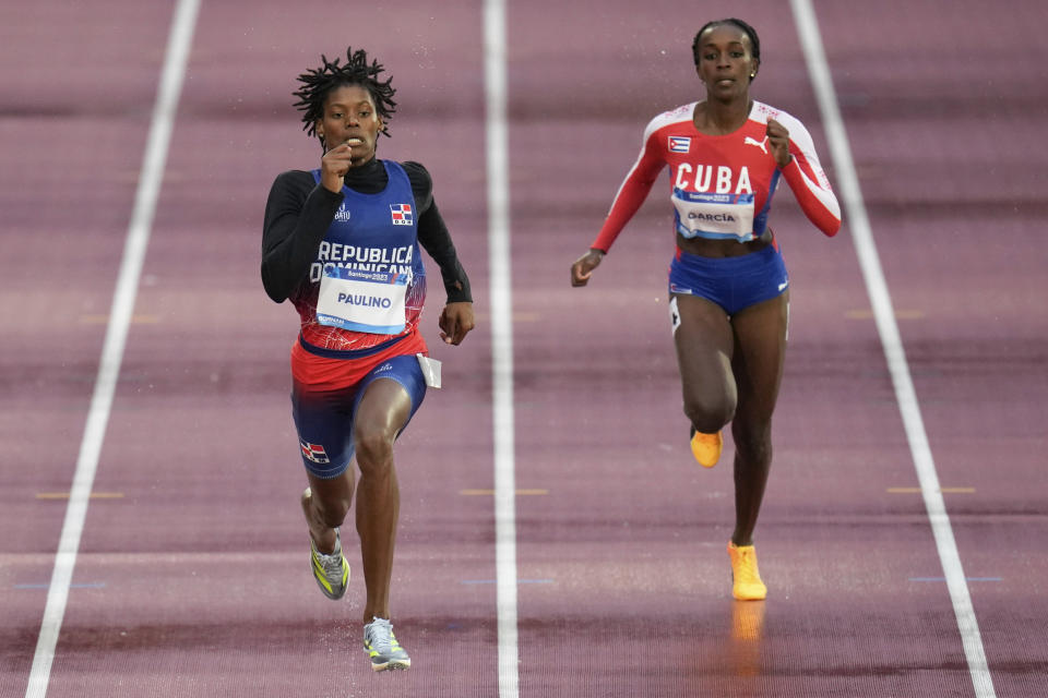 La dominicana Marileidy Paulino (izquierda) y la cubana Yunisleidy García compiten en los 200 metros femeninos del atletismo de los Juegos Panamericanos en Santiago, Chile, el miércoles 1 de noviembre de 2023. (AP Foto/Fernando Vergara)