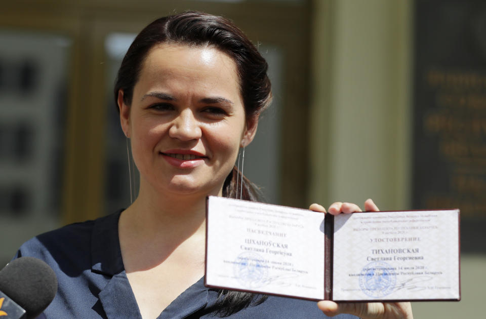 Svetlana Tikhanovskaya shows her presidential candidate's identification card after she was registered as a candidate for the presidential elections in Minsk, Belarus, Tuesday, July 14, 2020. The election commission has cleared Belarusian President Alexander Lukashenko and four other candidates for running in a presidential vote in August, but denied registration to Lukashenko's two main aspiring challengers. (AP Photo/Sergei Grits)