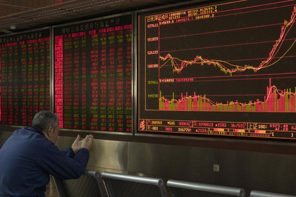 In this Thursday, Jan. 16, 2020, photo, an investor monitors stock prices at a brokerage in Beijing. Asian stock markets on Friday, Jan. 17 have followed Wall Street higher after China reported its economy grew by 6.1% in 2019 and Washington and Beijing signed an interim trade agreement. (AP Photo/Ng Han Guan)