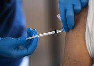 A health worker administers a Pfizer's COVID-19 vaccine at a temporary vaccination clinic in a church in Sollentuna, north of Stockholm, Sweden, Tuesday March 2, 2021. (Fredrik Sandberg/TT via AP)