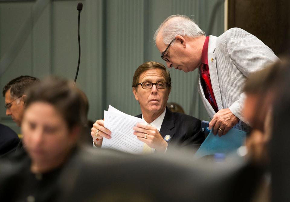 Rep. Danny Short, right, talks with Rep. Mike Ramone during the final session of the legislative season in 2016.