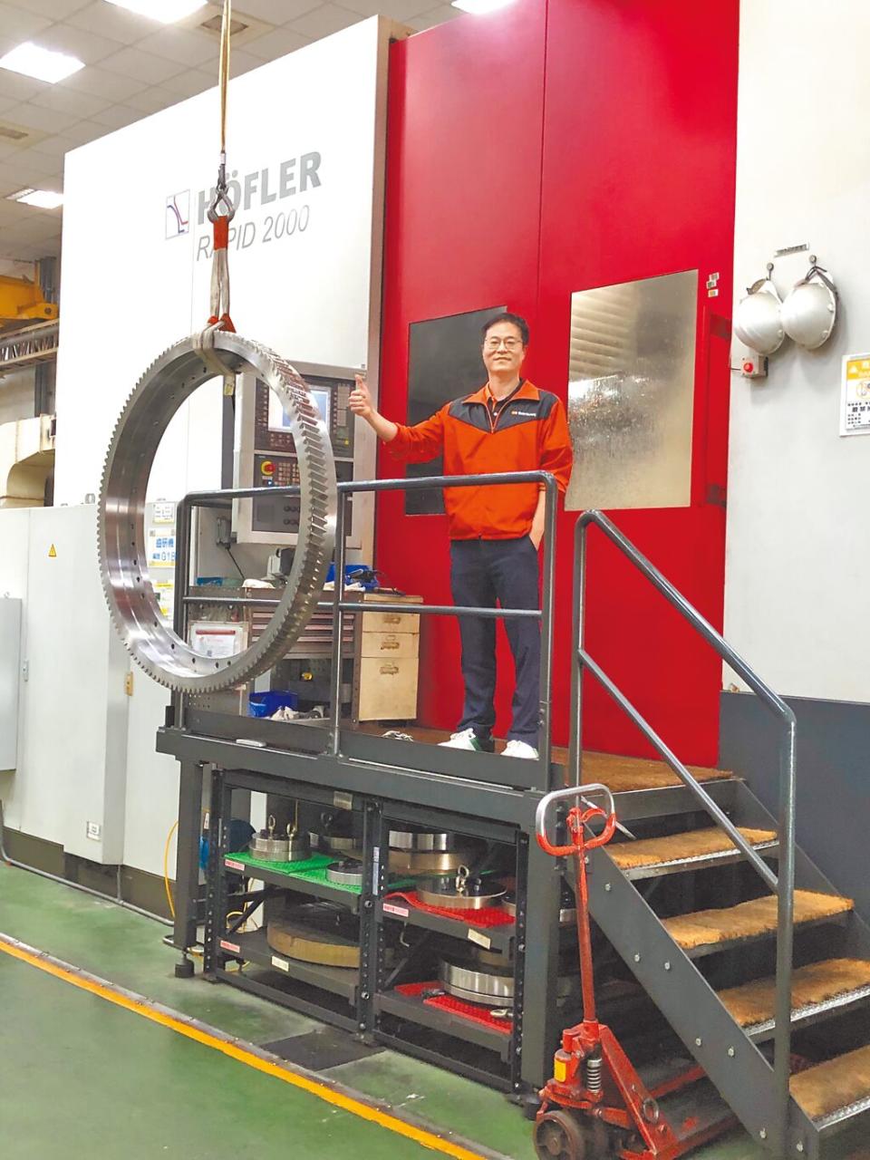 台穩董事長特助鄭生懋與德商HOFLER高階齒輪研磨機，最大可生產直徑達2米的精密齒輪。圖／莊富安
