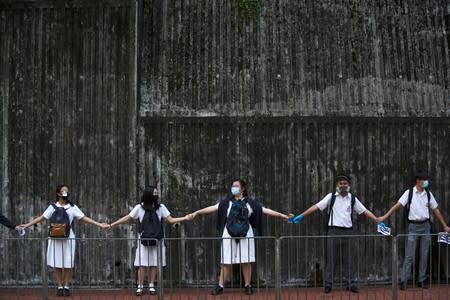 Secondary school students hold hands as they form a human chain in Hong Kong