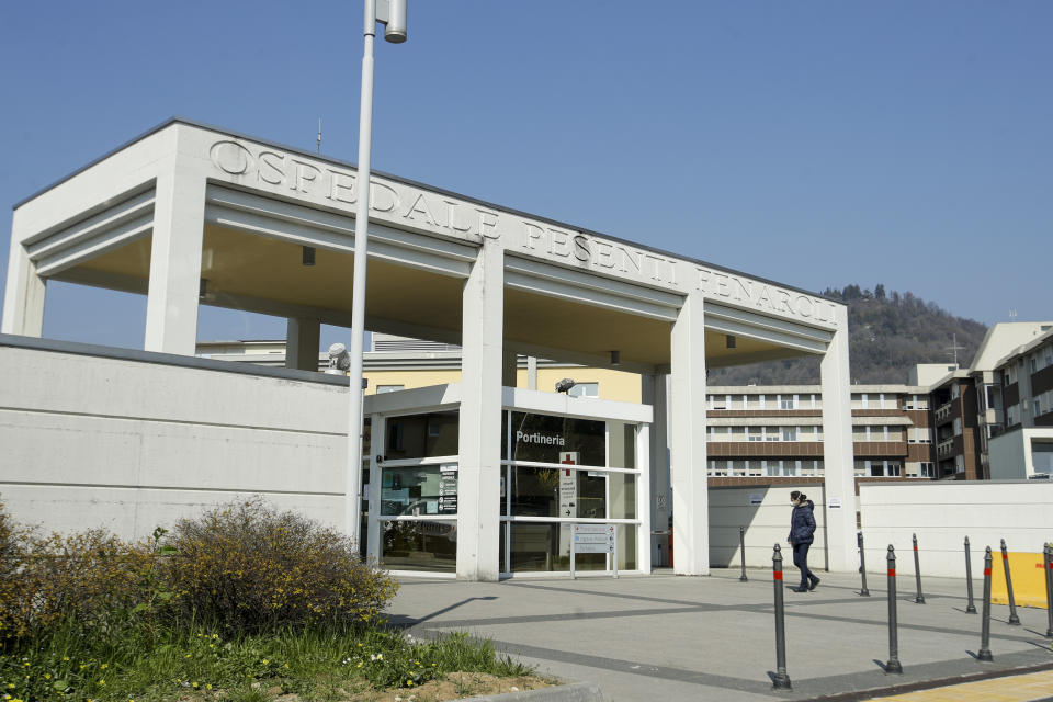 FILE - In this Tuesday, March 17, 2020 file photo, a woman walks outside the Pesenti Fenaroli hospital, in Alzano Lombardo, near Bergamo, the heart of the hardest-hit province in Italy's hardest-hit region of Lombardy, Italy. As Italy prepares to emerge from the West’s first and most extensive coronavirus lockdown, it is increasingly becoming apparent that something went terribly wrong in Lombardy, the hardest-hit region in Europe’s hardest-hit country. Two days after Italy registered its first positive case in the Lombard town of Codogno, sparking a lockdown of Codogno and nine nearby towns, another positive case was registered Feb. 23 more than an hour’s drive away in the hospital of Alzano Lombardo in the province of Bergamo. Whereas the emergency room of Codogno’s hospital was shuttered after its first positive case, the ER of Alzano’s hospital reopened after a few hours of cleaning, fast becoming one of Bergamo’s main sources of contagion. (AP Photo/Luca Bruno, File)