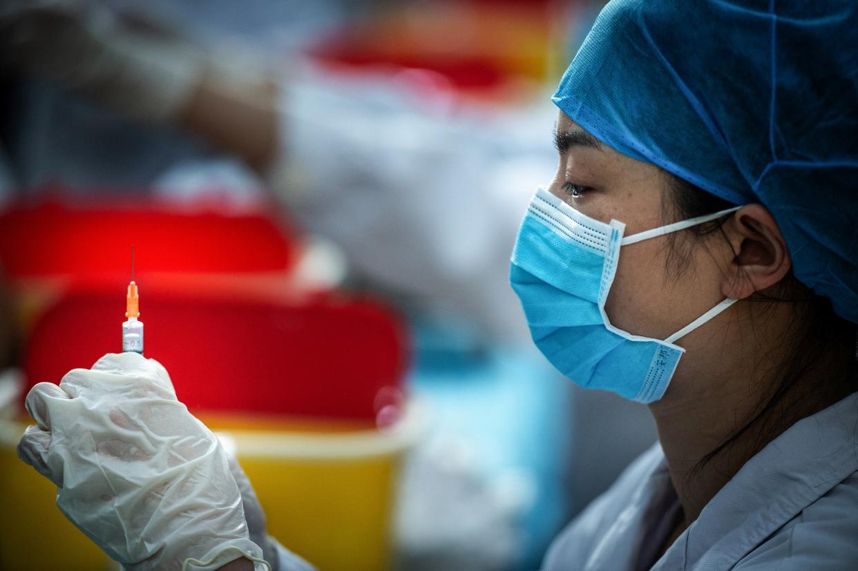 <p>File Image: This photo taken on 28 April 2021 shows a medical staff member preparing a dose for a university student to get vaccinated against the Covid-19 coronavirus at a university in Wuhan, in China's central Hubei province</p> (AFP via Getty Images)