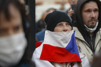 A woman wears a Czech flag as a mask as demonstrators gather to protest the COVID-19 preventative measures downtown Prague, Czech Republic, Wednesday, Oct. 28, 2020. Coronavirus infections in the Czech Republic have again jumped to record levels amid new restrictive measures imposed by the government to curb the spread. (AP Photo/Petr David Josek)