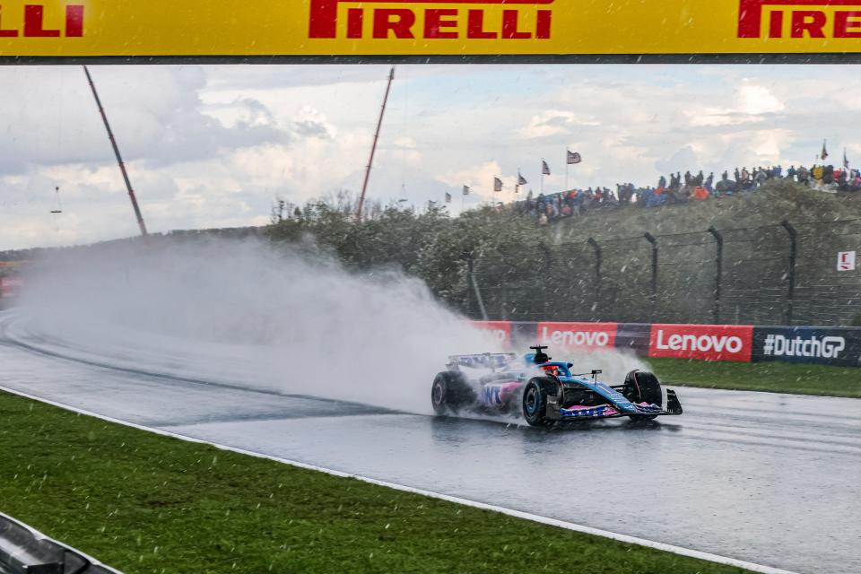 Car driving through wet race track