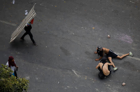 Demonstrators lay on the ground as they react to the sound of gunfire during clashes with security forces following a rally against the government of Venezuela's President Nicolas Maduro and to commemorate May Day in Caracas Venezuela, May 1, 2019. REUTERS/Adriana Loureiro