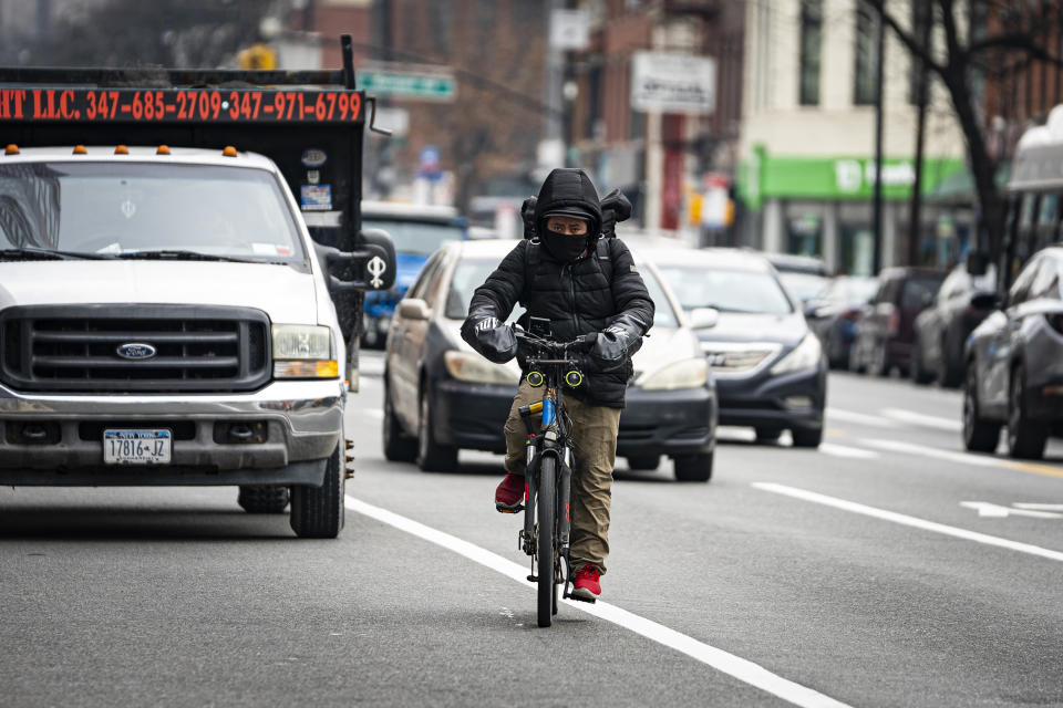A food delivery worker on a bicycle rides north on Flatbush Avenue on Thursday, Feb. 1, 2024, in New York. A wage law in New York City meant to protect food delivery workers is getting backlash from app companies like Uber, GrubHub and DoorDash, who have cut worker hours and made it more difficult to tip. (AP Photo/Peter K. Afriyie)