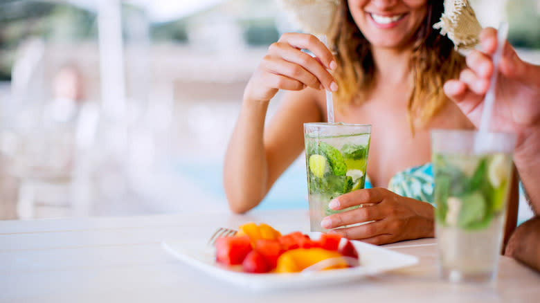 People drinking mojitos in a poolside bar