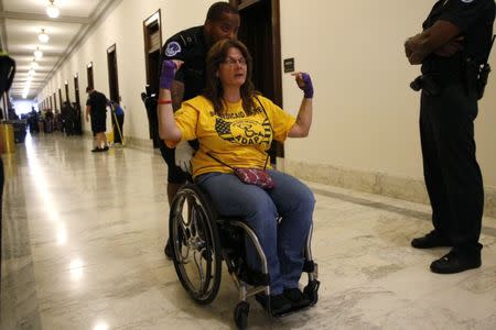 A protester calling for "no cuts to Medicaid" is escorted away by police after being arrested during a demonstration outside Senate Majority Leader Mitch McConnell's constituent office after Senate Republicans unveiled their healthcare bill on Capitol Hill in Washington, U.S., June 22, 2017. REUTERS/Kevin Lamarque