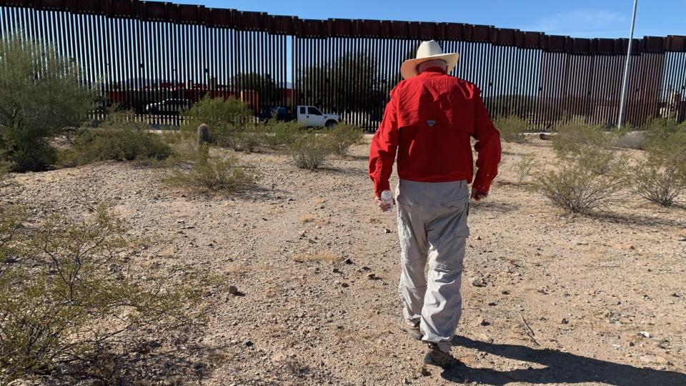 Tom Wingo, a volunteer with Humane Borders, a humanitarian aid nonprofit, approaches a welder from the Border Patrol who watches over a section of the 30-foot bollard fence that was cut down by human smugglers on November 1, 2023.