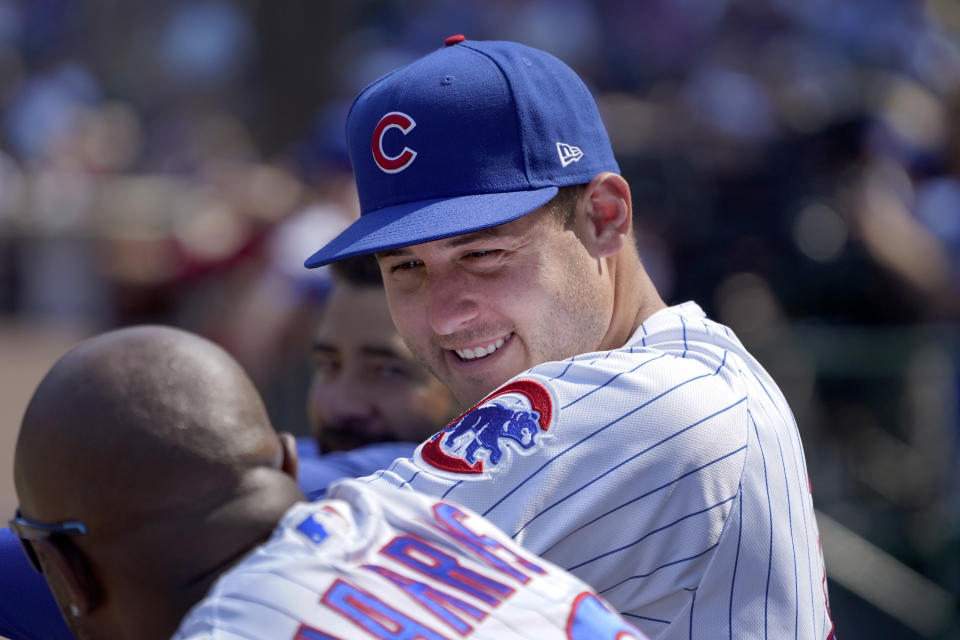 Chicago Cubs' Anthony Rizzo, right, talks with third base coach Willie Harris in the dugout during the seventh inning of a baseball game against the Cincinnati Reds Thursday, July 29, 2021, in Chicago. (AP Photo/Charles Rex Arbogast)