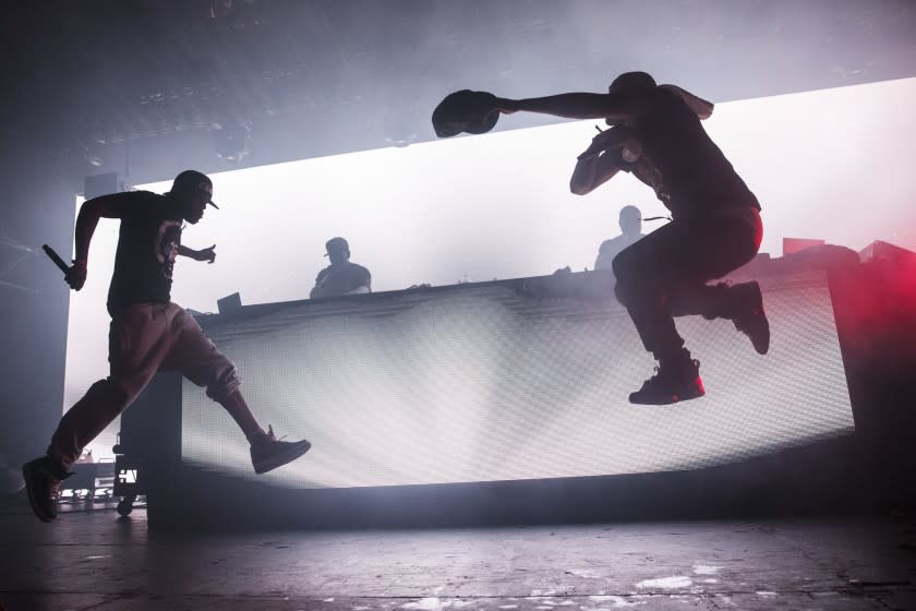 The silhouettes of Method Man and Redman jumping in the air while performing