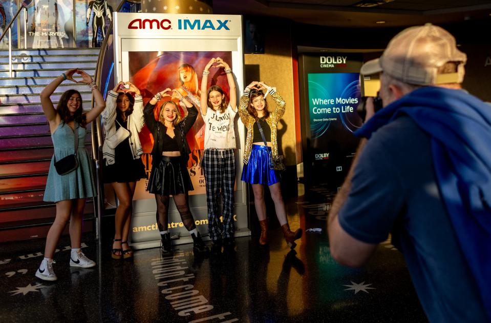 Teens make a heart sign while posing for a group photo before attending Taylor Swift's concert movie at the AMC theater on October 13, 2023 in Century City, California.(