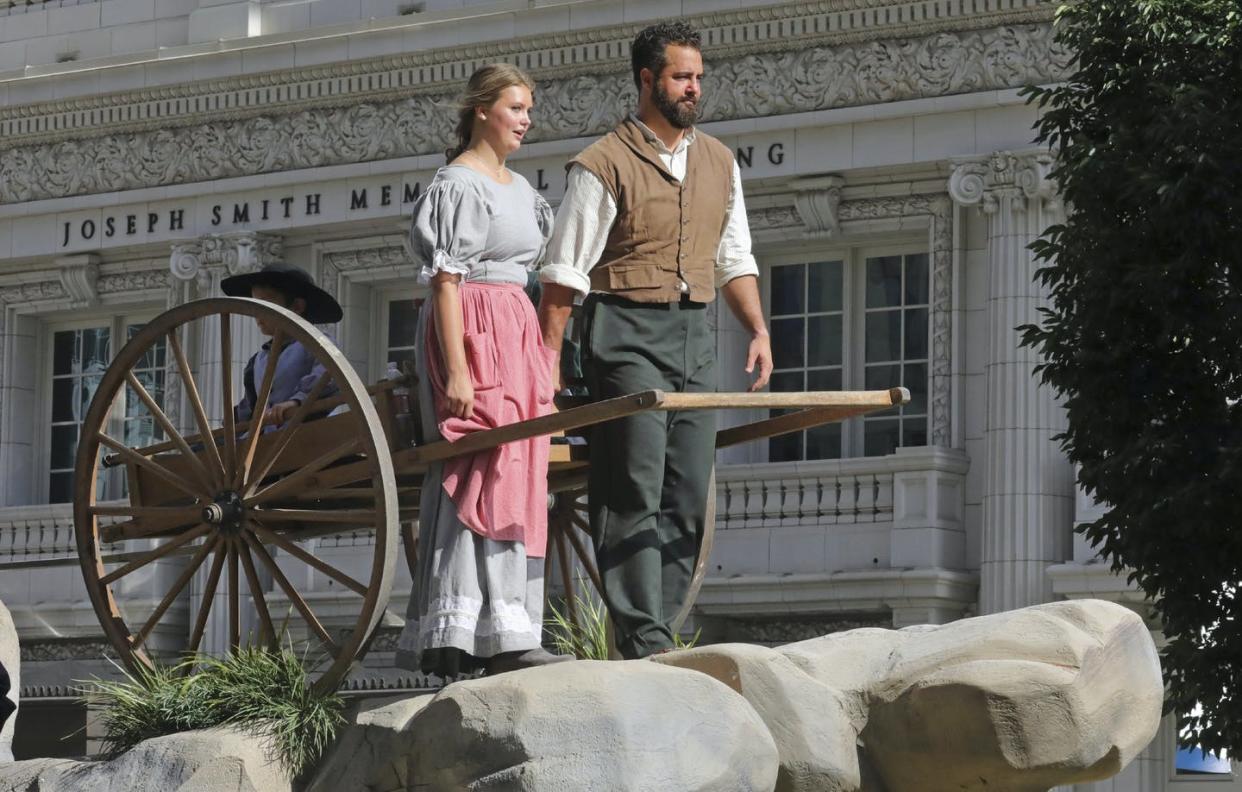 A couple rides on a float with a handcart during the parade for Pioneer Day, an annual Utah holiday, on July 24, 2019, in Salt Lake City. <a href="https://newsroom.ap.org/detail/PioneerDayUtah/34e6e0d87bbc4d9283f3f6ddcbb6db5e/photo?Query=%22pioneer%20day%22&mediaType=photo&sortBy=arrivaldatetime:desc&dateRange=Anytime&totalCount=53&currentItemNo=11" rel="nofollow noopener" target="_blank" data-ylk="slk:AP Photo/Rick Bowmer;elm:context_link;itc:0;sec:content-canvas" class="link ">AP Photo/Rick Bowmer</a>