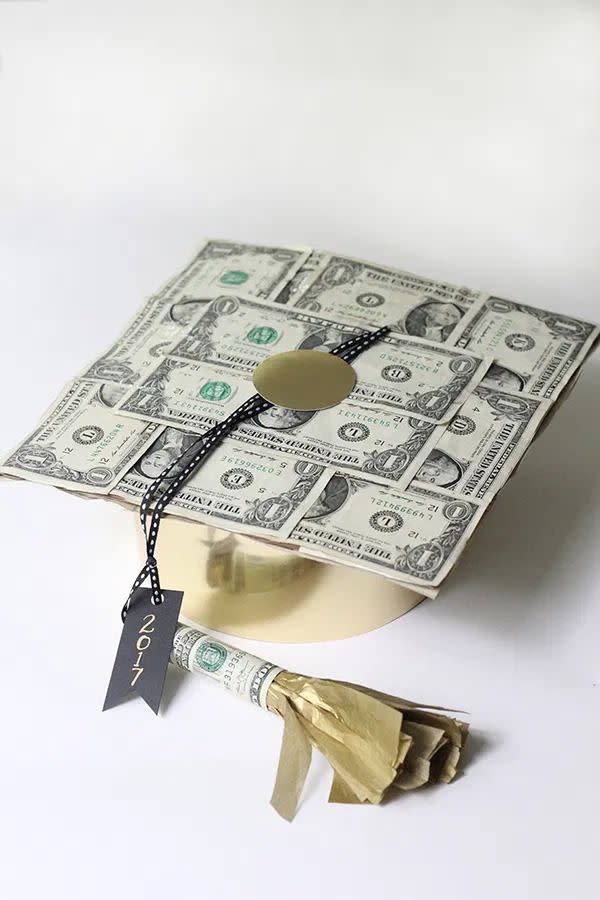graduation cap decorated with dollar bills