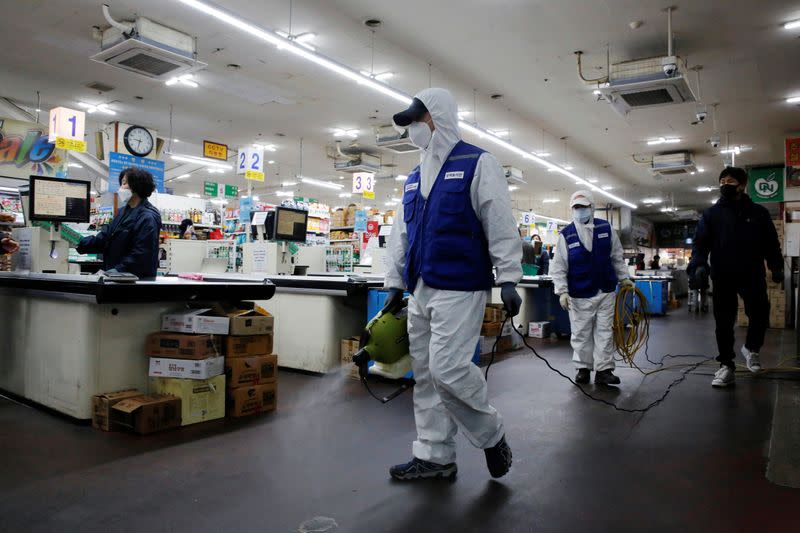 An employee from a disinfection service company sanitizes at a market in Seoul