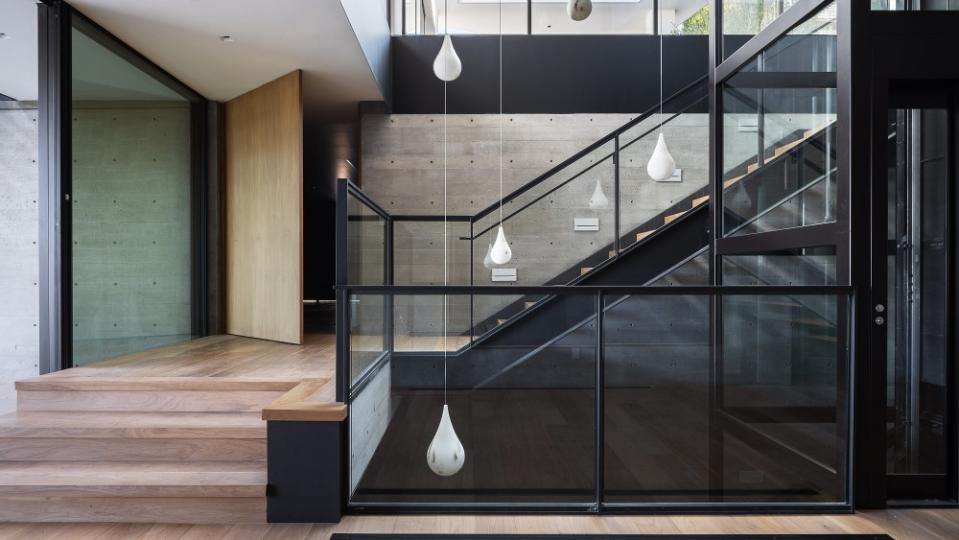 The striking staircase and artful light fixtures welcome you into the home. - Credit: Mike Kelley