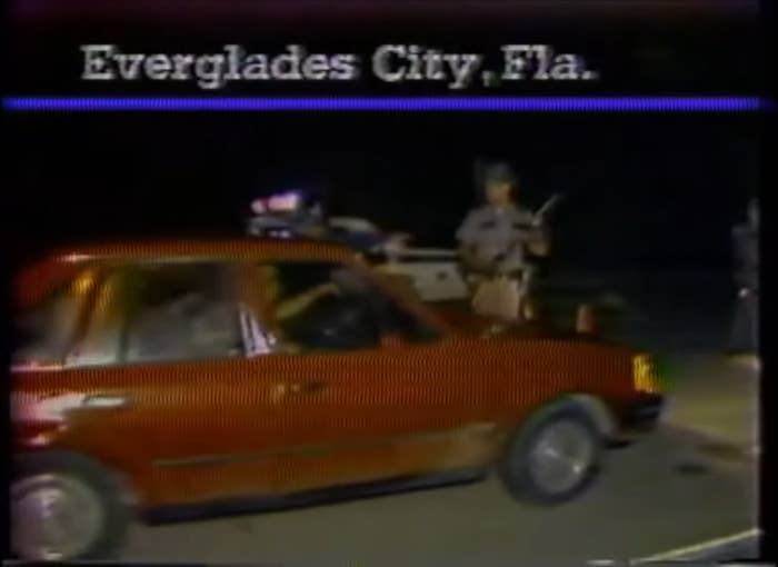 police officers standing by as a car drives by