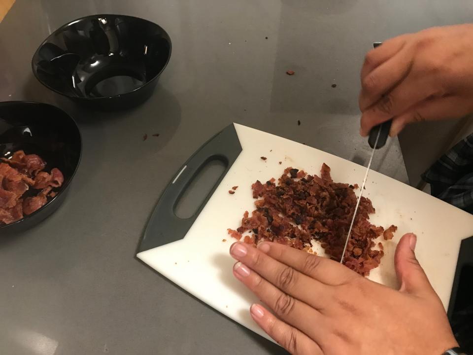 Chopping slices of bacon to bake Martha Stewart's Bacon Potato-Chip Chocolate Cookie recipe.