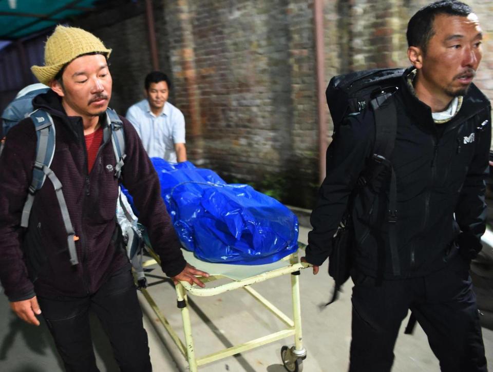 Volunteers and friends carry the body of Japanese climber Nobukazu Kuriki (Getty Images)