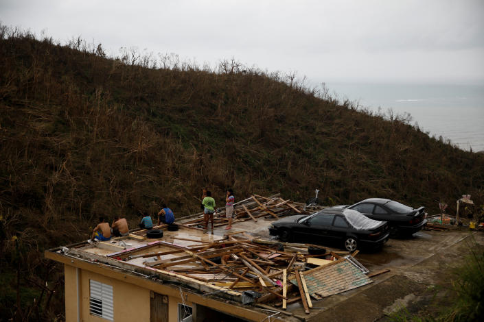 People stay at the roof of a damaged house after the area was hit by Hurricane Maria in Yabucoa, Puerto Rico September 22, 2017. REUTERS/Carlos Garcia Rawlins     TPX IMAGES OF THE DAY