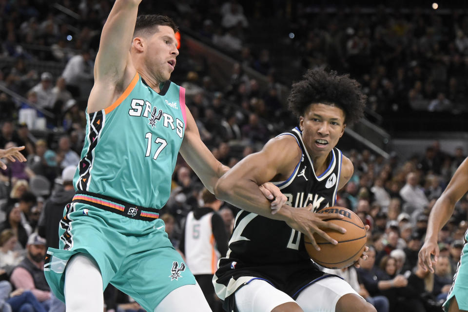 Milwaukee Bucks' MarJon Beauchamp, right, drives against San Antonio Spurs' Doug McDermott during the second half of an NBA basketball game, Friday, Nov. 11, 2022, in San Antonio. San Antonio won 111-93. (AP Photo/Darren Abate)