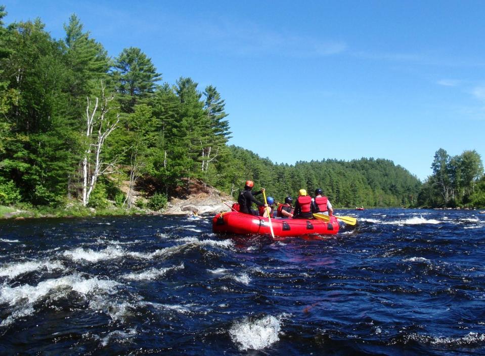 This Aug. 24, 2013 photo provided by the Adirondack Explorer shows Becky Pelton of North Creek Rafting guiding her raft of clients through the last rapids of the Hudson River Gorge in Minerva, N.Y. Nate Pelton's North Creek Rafting Co. was the only outfitter offering ducky trips this season through the Hudson River Gorge. You ride atop duckies, back and feet braced against inflated thwarts, flanked by gunwale tubes almost a foot high. (AP Photo/Adirondack Explorer, Phil Brown)