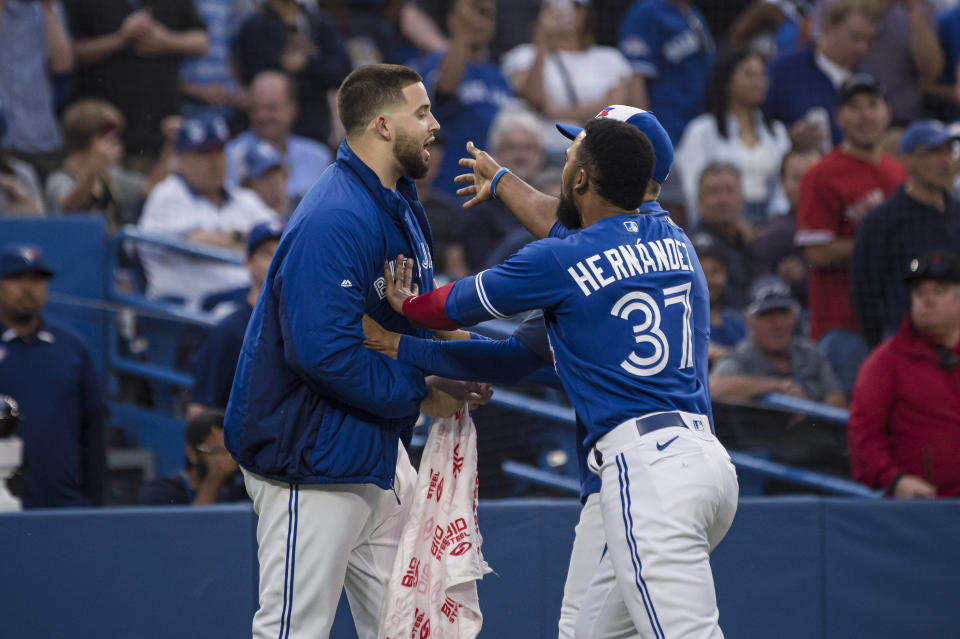 Toronto Blue Jays pitcher Alek Manoah, left, is held back by outfielder Teoscar Hernandez during a heated exchange with the Boston Red Sox after Blue Jays' Alejandro Kirk was hit by a pitch during the fourth inning of a baseball game Wednesday, June 29, 2022, in Toronto. (Christopher Katsarov/The Canadian Press via AP)