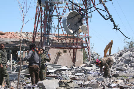 Fighters from the Kurdish People's Protection Units (YPG) inspect the damage at their headquarters after it was hit by Turkish airstrikes in Mount Karachok near Malikiya, Syria. REUTERS/ Rodi Said