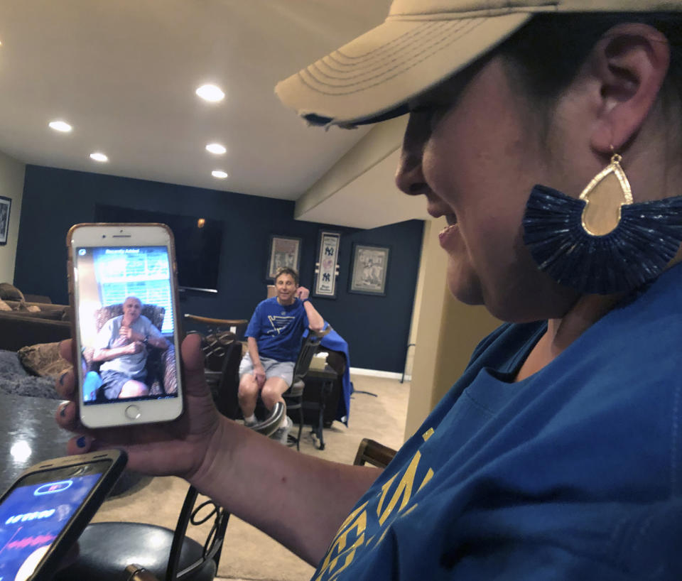 Patrick Maroon's sister, Jen Guetschow, holds up her phone to play a video of their late grandfather, Ernest Ferrara, welcoming Maroon back to St. Louis after he signed with the Blues as his aunt, Jan Phegley, looks on in St. Louis, Mo., Friday, May 31, 2019. Patrick Maroon had other offers for more money and more years but chose to sign with his hometown St. Louis Blues. He did it for family: for his young son Anthony, his parents and his grandfather, who then died the day before the team left for the playoffs. That day, Maroon said he'd win the Stanley Cup for his late grandfather Ernie and he and the Blues are two wins away from making a lifelong dream come true. (AP Photo/Stephen Whyno)