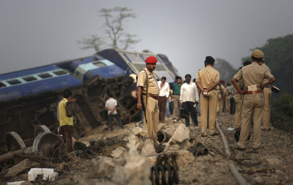 Indian policemen stand by a train that derailed near Jagiroad Railway Station, about 90 kilometers (56 miles) east of Gauhati, India, Wednesday, April 16, 2014. According to a Northeast Frontier Railway officer, dozens of people were injured when the train jumped the tracks and derailed early Wednesday. (AP Photo/Anupam Nath)